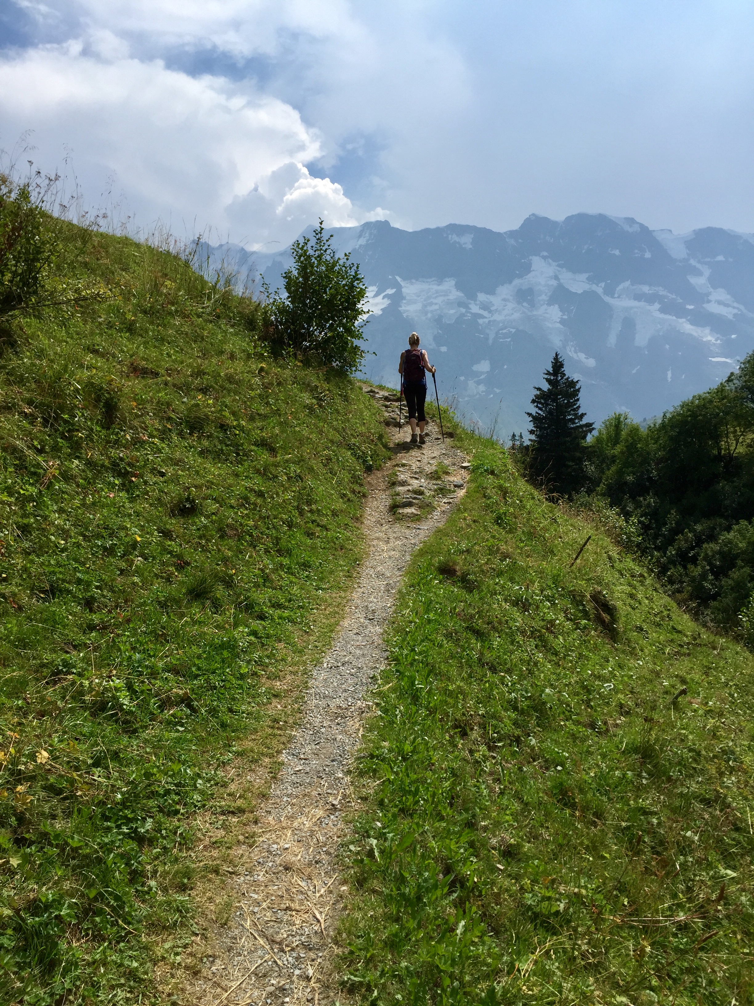 Hiker in a hiking path heading upward and toward Gimmelwald