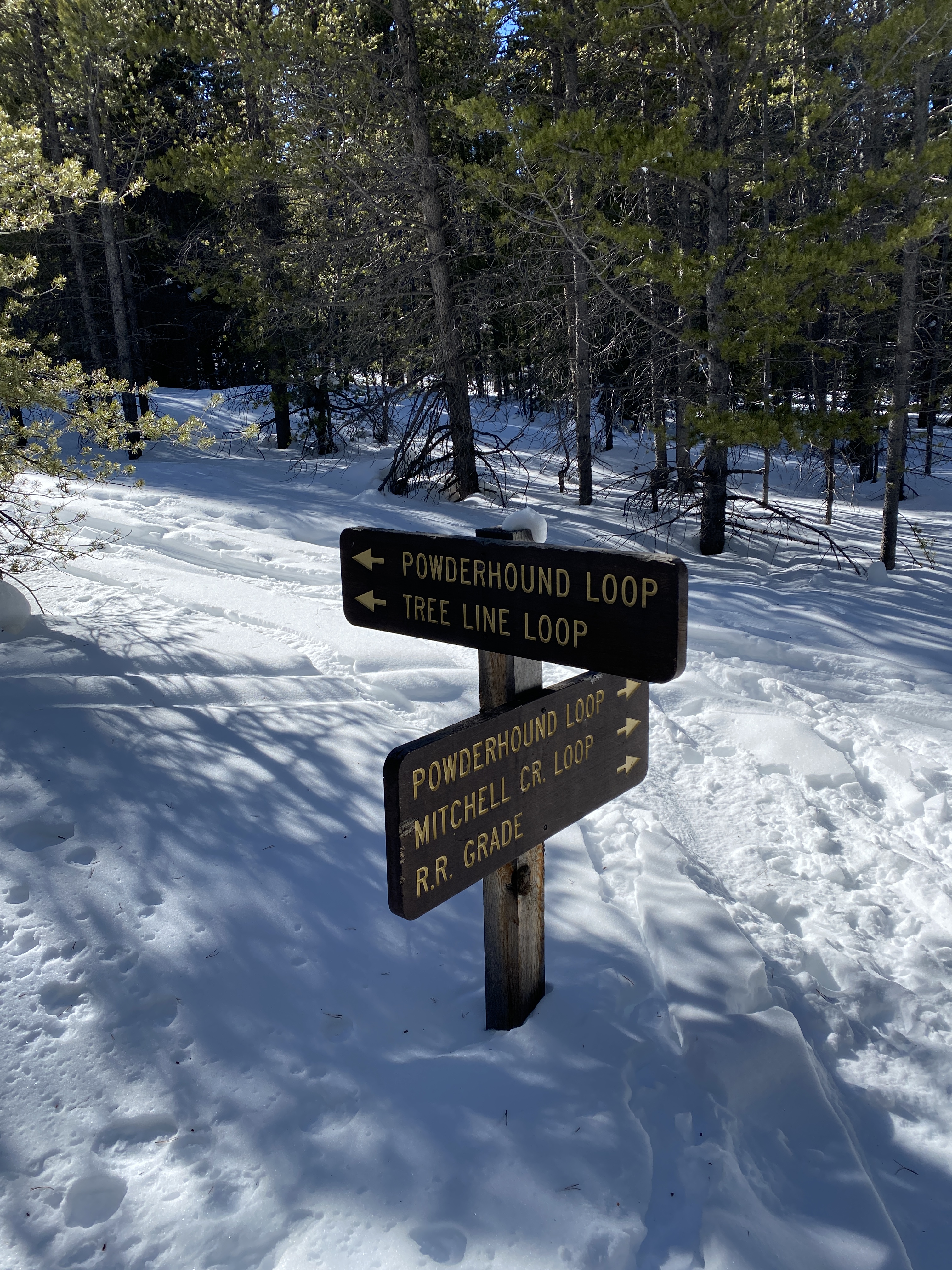 hiking signs in snow for Powderhound loop snowshoeing trail